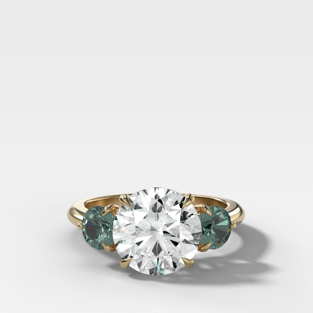 Martini Three Stone Engagement Ring With Round Cut Diamond and Green Sapphires