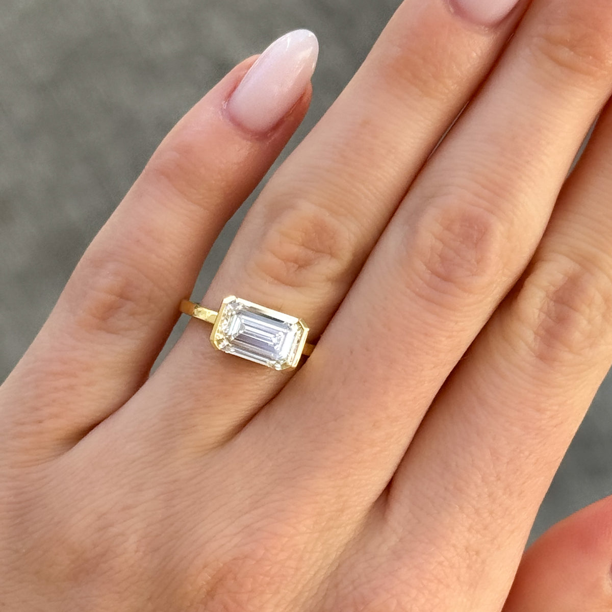 East West Half Bezel Solitaire Engagement Ring With Emerald Cut Diamond