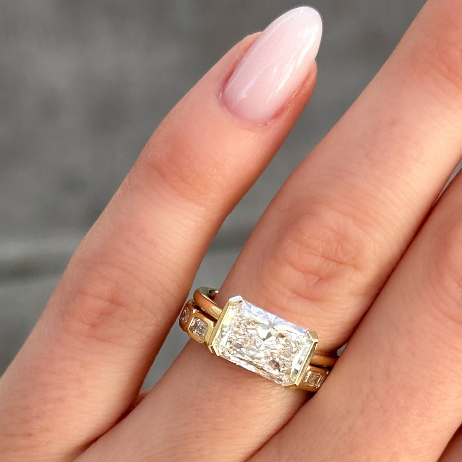 Banda de eternidad con engaste de bisel para bebé con tallas de esmeralda East West en oro amarillo de Good Stone