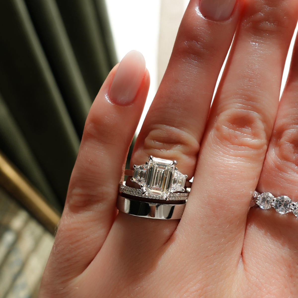 Three Stone ring with Trapezoid side diamonds and an Emerald cut