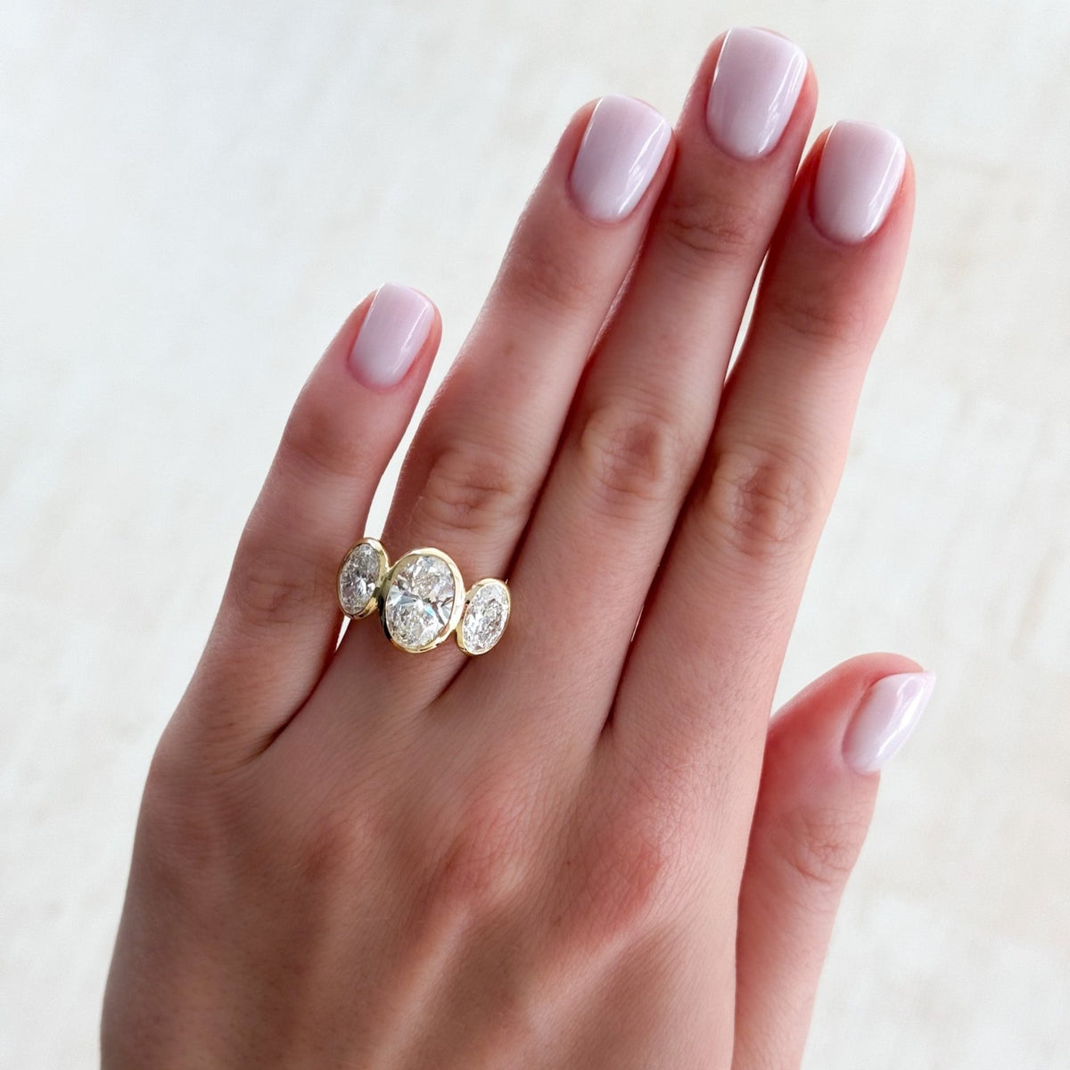 Penumbra Bezel Triad Engagement Ring With Oval Cut Diamonds - GOODSTONE