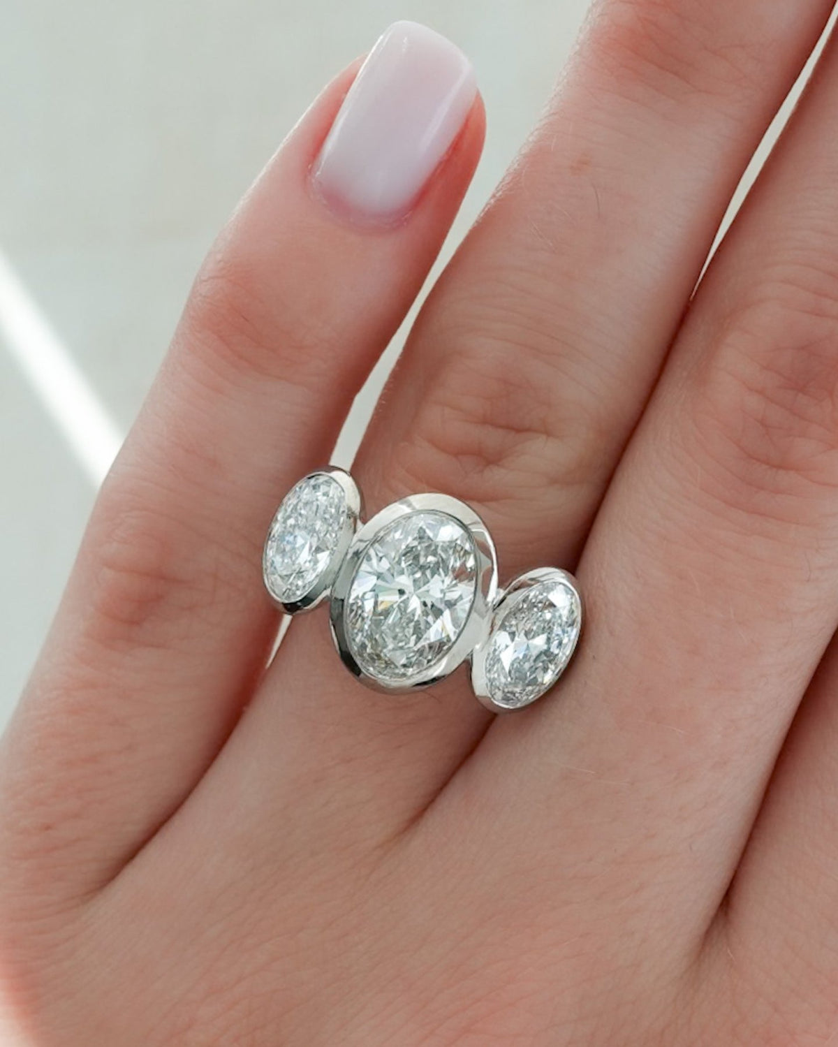 Penumbra Bezel Triad Engagement Ring With Oval Cut Diamonds - GOODSTONE