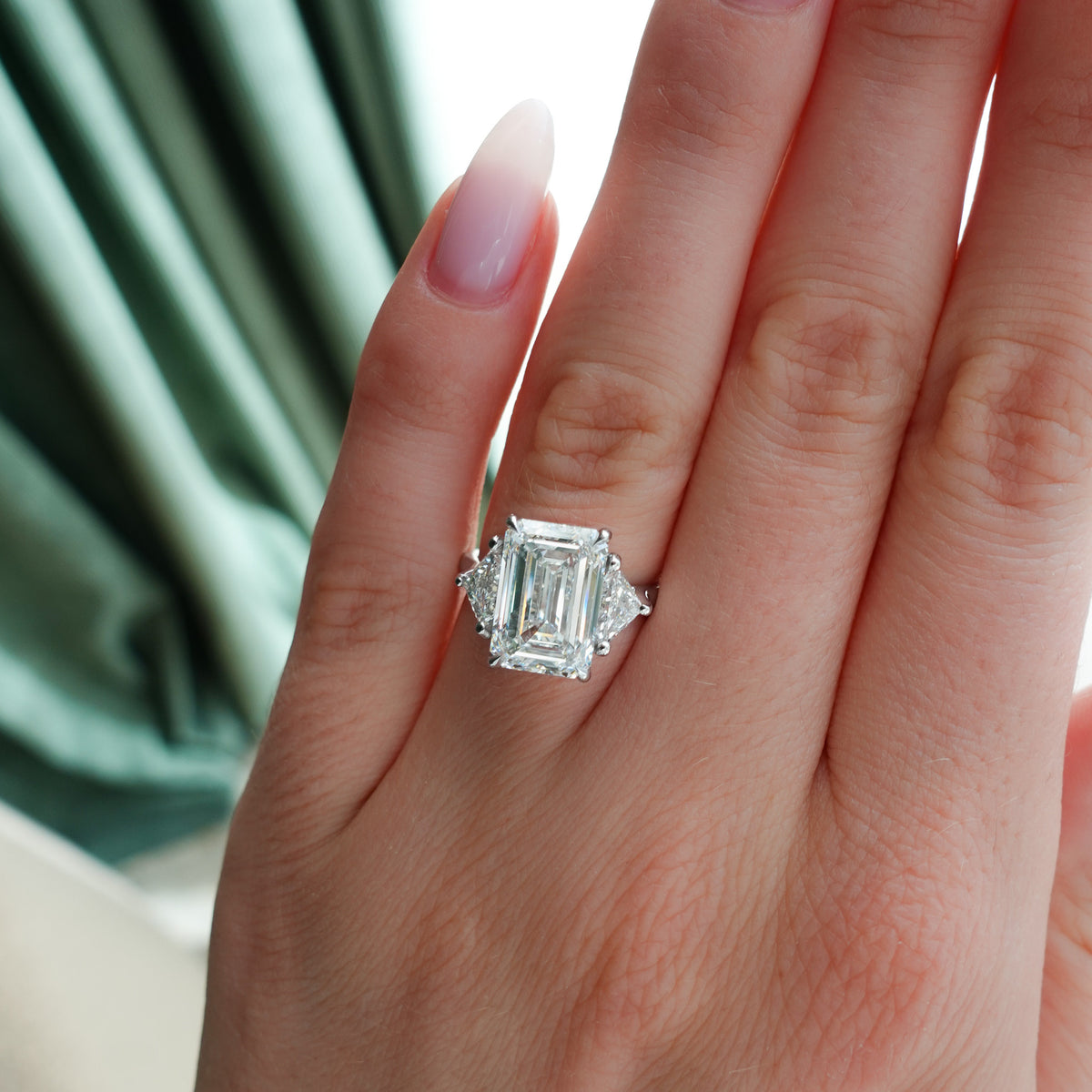 Three Stone Engagement Ring with Shield Side Stones and an Emerald Cut Diamond