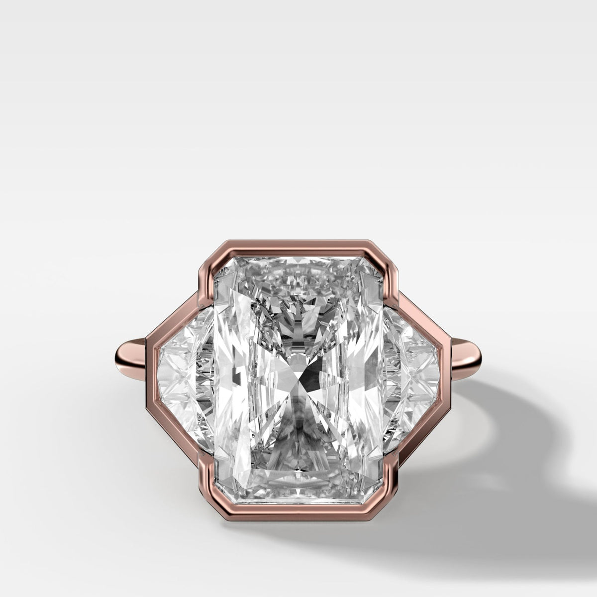 Three Stone Bezel Set Engagement Ring with Trapezoid Side Diamonds and an Elongated Radiant Cut - GOODSTONE