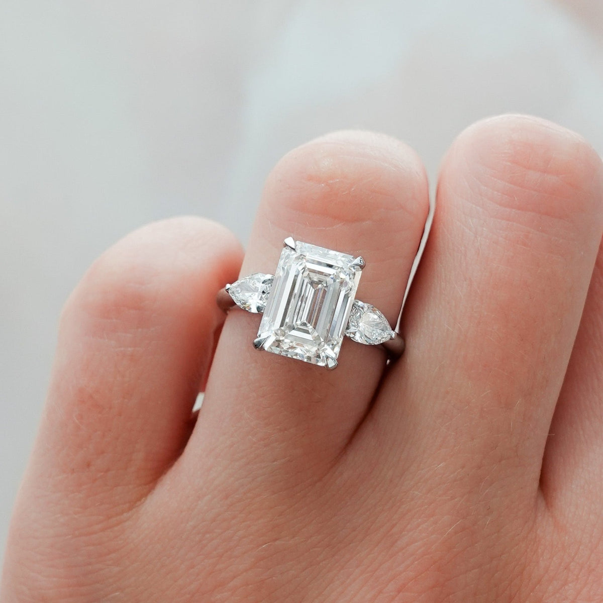 Three Stone Engagement Ring With Pear Side Stones and Emerald Cut Diamond - GOODSTONE