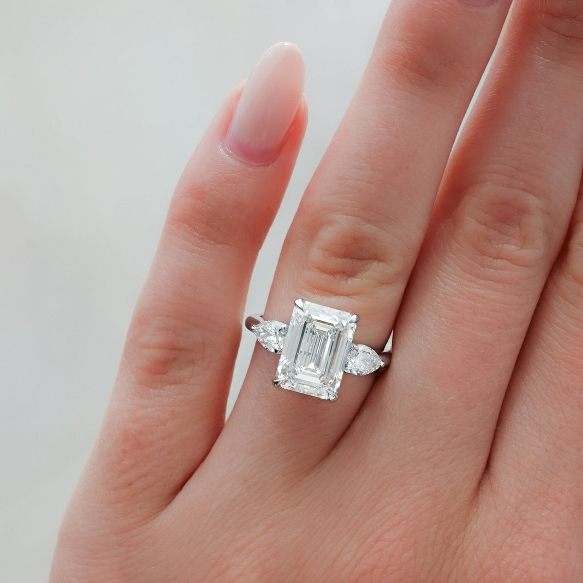 Three Stone Engagement Ring With Pear Side Stones and Emerald Cut Diamond - GOODSTONE