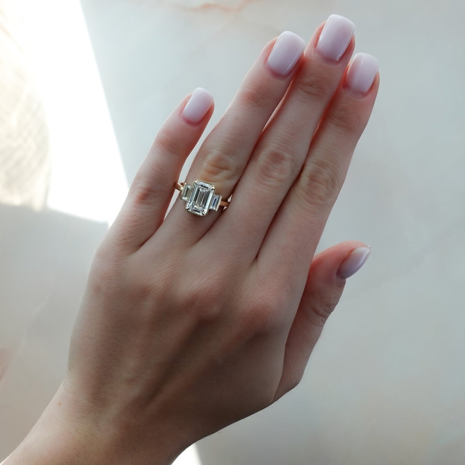 Anillo de compromiso de tres piedras con piedras laterales de talla baguette rectas y talla esmeralda de Good Stone en oro amarillo