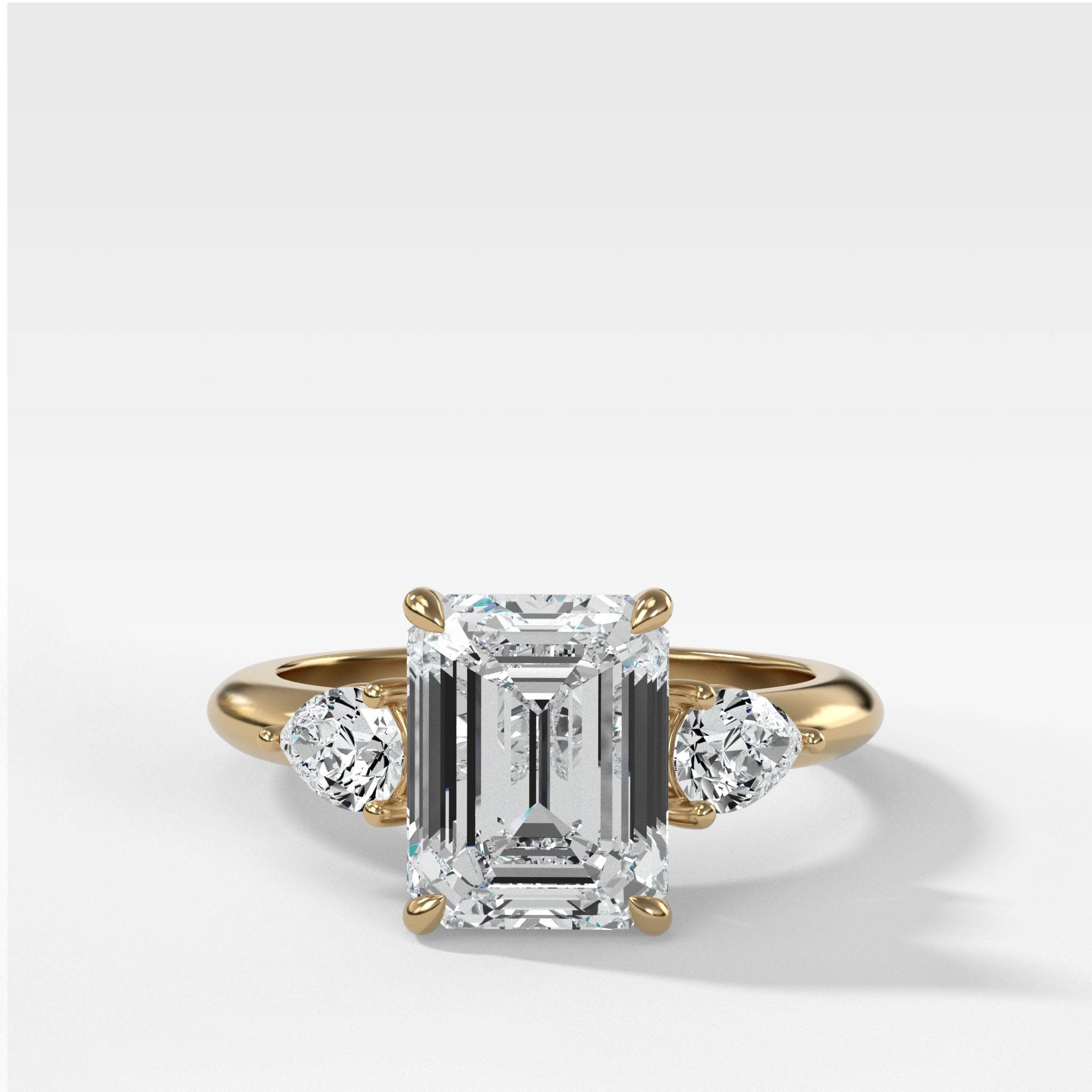 Three Stone Engagement Ring With Pear Side Stones and Emerald Cut by Good Stone in Yellow Gold